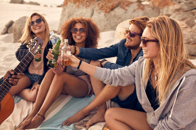 一群朋友在海滩上和啤酒干杯